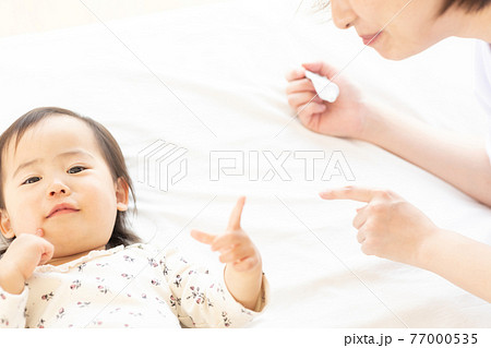 保湿クリームをつけるママと幼児 77000535