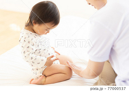 保湿クリームをつけるママと幼児 77000537