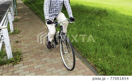 春にサイクリングをする男性（スポーツタイプの自転車のクロスバイク） 77001654