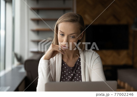 Pensive female employee work on computer in office Pensive female employee work on computer in office 77002246