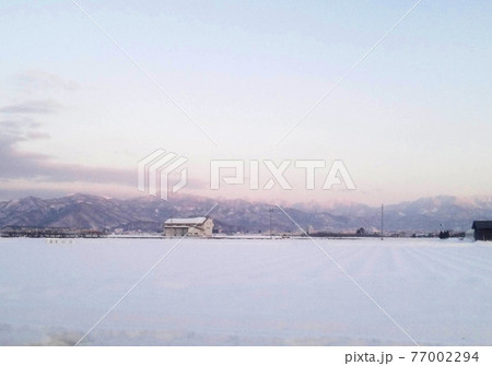 雪の東北の田園風景 77002294