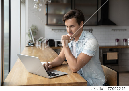 Caucasian man work on laptop in office thinking 77002295