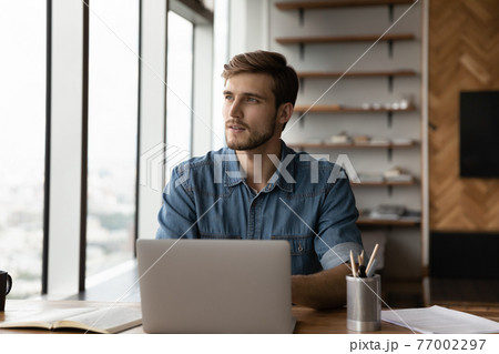 Pensive Caucasian man work on laptop thinking 77002297
