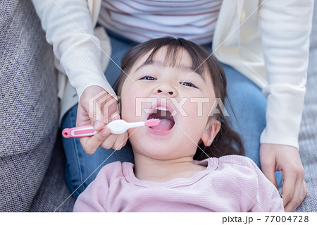 ライフスタイル　歯磨き　ママに仕上げ磨きをしてもらう女の子 77004728