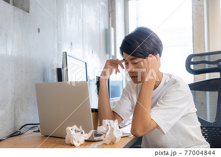 体調不良の20代男性　考え事しているイメージ　 77004844