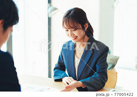 接客をするスーツの女性 接客をするスーツの女性 77005422