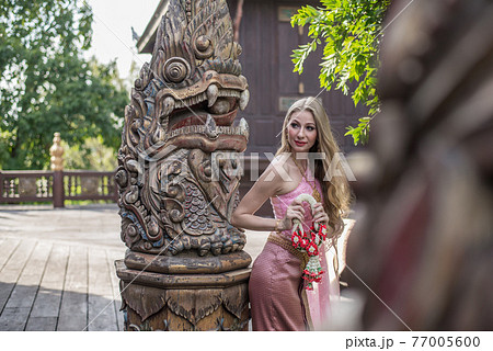 Beautiful girl in the Thai national bright dress with oriental makeup, travel in Thailand Beautiful girl in the Thai national bright dress with oriental makeup, travel in Thailand 77005600