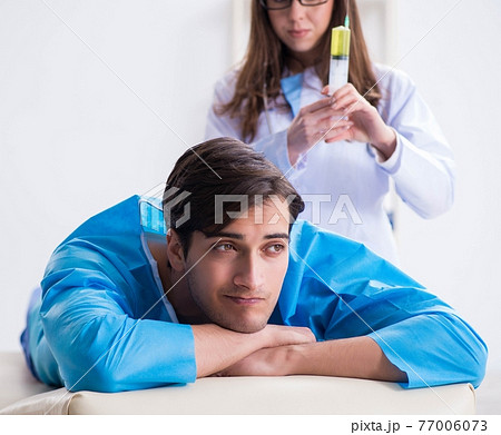 Funny man getting ready for buttocks syringe shot Funny man getting ready for buttocks syringe shot 77006073