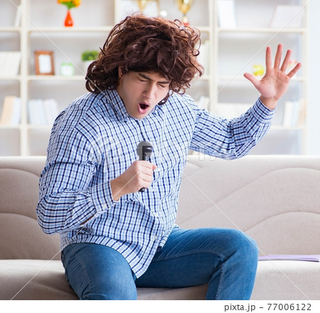 Funny man singing songs in karaoke at home 77006122