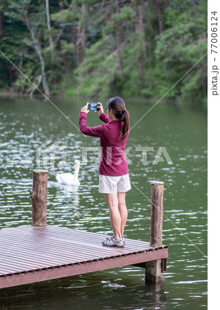 Happy traveler woman taking photo Nature view by smartphone , solo tourist in sweater traveling at Pang Oung, Mae Hong Son, Thailand. travel, trip and vacation concept Happy traveler woman taking photo Nature view by smartphone , solo tourist in sweater traveling at Pang Oung, Mae Hong Son, Thailand. travel, trip and vacation concept 77006124