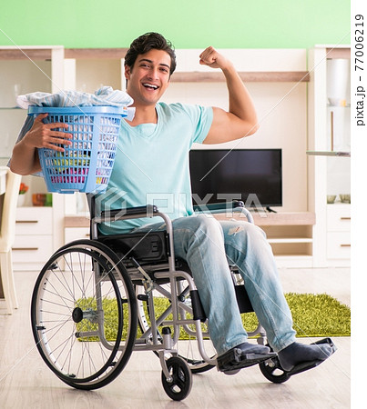 Disabled man on wheelchair doing laundry Disabled man on wheelchair doing laundry 77006219