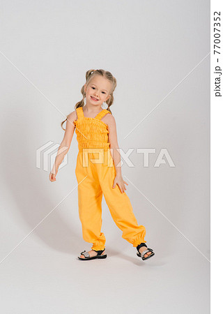 Portrait of a cheerful girl jumping and dancing against a studio background Portrait of a cheerful girl jumping and dancing against a studio background 77007352