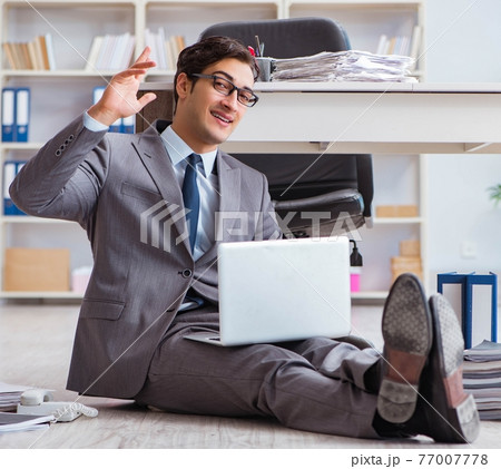 Businessman working and sitting on floor in office 77007778