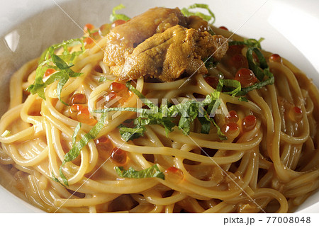 湯気が立つ生ウニとイクラが乗っているウニクリームソースパスタ 77008048