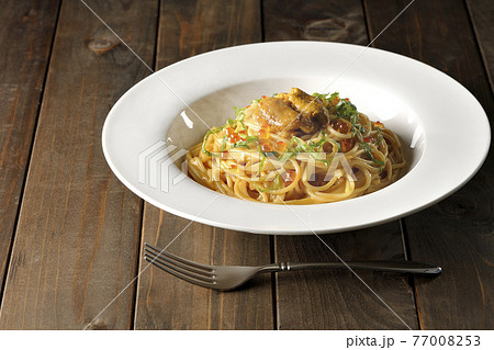 湯気が立つ、生ウニとイクラが乗っているウニクリームソースパスタとフォーク 77008253