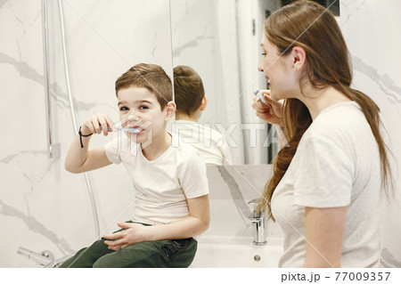 Mother teaches her little son how to brush teeth Mother teaches her little son how to brush teeth 77009357