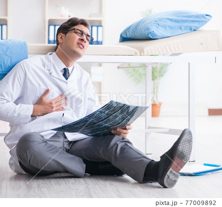 Doctor sitting on the floor in hospital 77009892