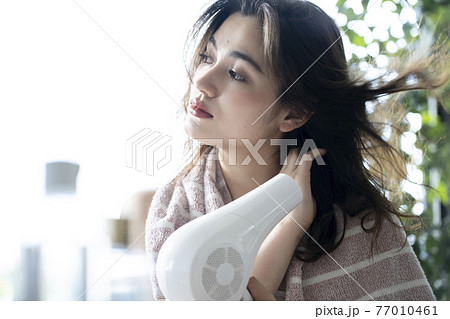 髪をドライヤーで乾かす女性 髪をドライヤーで乾かす女性 77010461