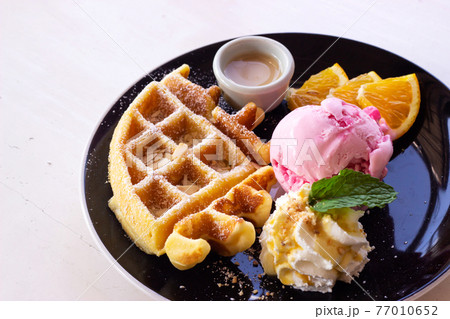 Homemade waffle served with strawberry ice cream. Sweet dessert. Homemade waffle served with strawberry ice cream. Sweet dessert. 77010652