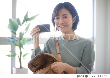 コンパクトデジタルカメラを持つ女性 77011576