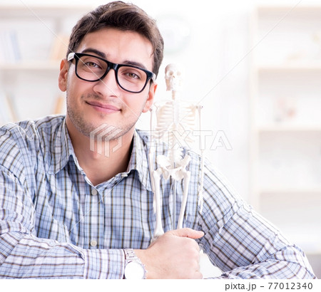 Medical student studing the skeleton 77012340