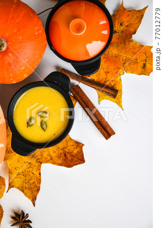 Autumn food. Pumpkin puree soup, leaves. Top view. Autumn harvest, pumpkins, leaves on grey as abstract background. Thanksgiving day. Flat lay. Autumn food. Pumpkin puree soup, leaves. Top view. Autumn harvest, pumpkins, leaves on grey as abstract background. Thanksgiving day. Flat lay. 77012779