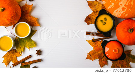 Autumn food. Frame of pumpkin puree soup, leaves. Top view. Autumn harvest, pumpkins, leaves on grey as abstract background. Thanksgiving day. Flat lay. Copy space 77012780