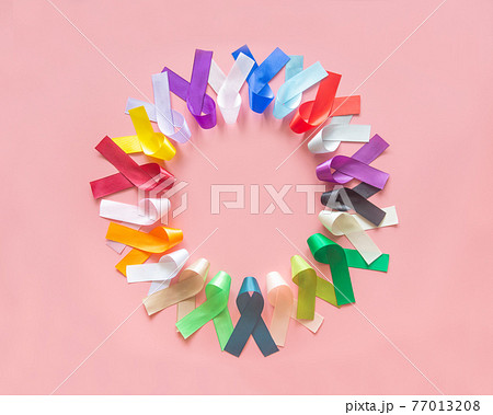 Colorful ribbons bow on pastel pink background in top view flat lay with copy space for text. World cancer day campaign concept on February 4, cancer awareness. National cancer survival day. 77013208