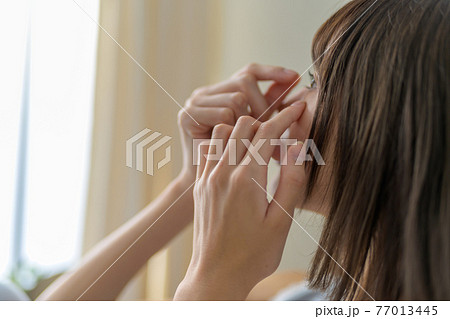 女性がコンタクトレンズを外す 77013445