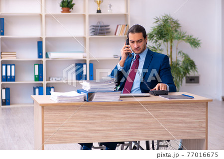 Young disabled employee working in the office 77016675