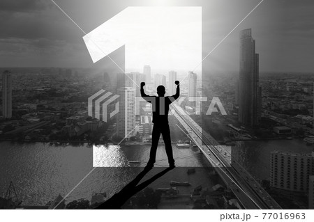 Double exposure silhouette of man standing inside number one with fists raising up over the city background 77016963