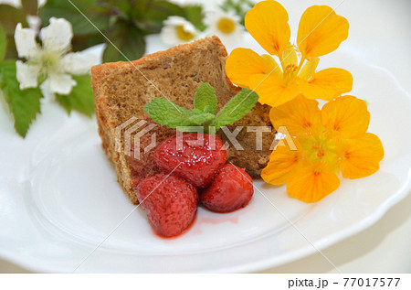 手作りのコーヒーシフォンケーキの一切れ 食用花といちごジャム付きの写真素材