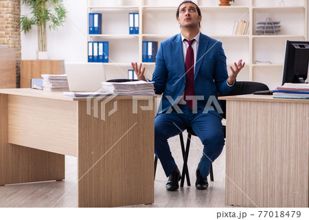 Young male employee in multitasking concept Young male employee in multitasking concept 77018479