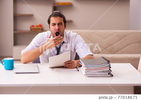 Young male employee working from home during pandemic 77018675