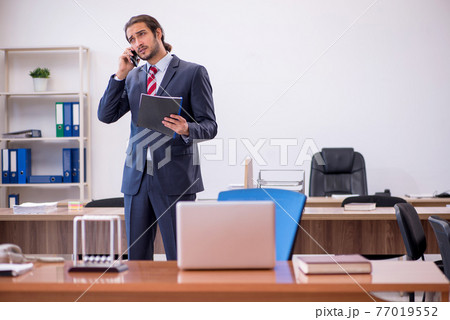 Young man businessman employee sitting in the office Young man businessman employee sitting in the office 77019552