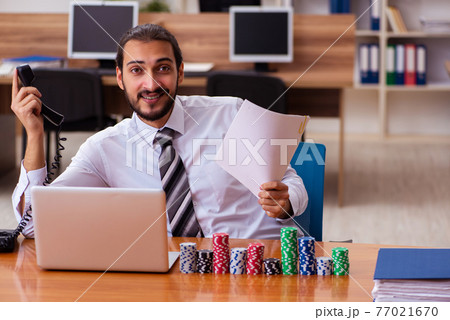 Young male employee in gambling concept 77021670