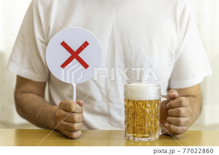 ビールを飲む男性と、falseサイン(30代、日本人) ビールを飲む男性と、falseサイン(30代、日本人) 77022860