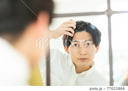 鏡を見る男性 77023866