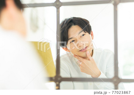 鏡を見る男性 77023867