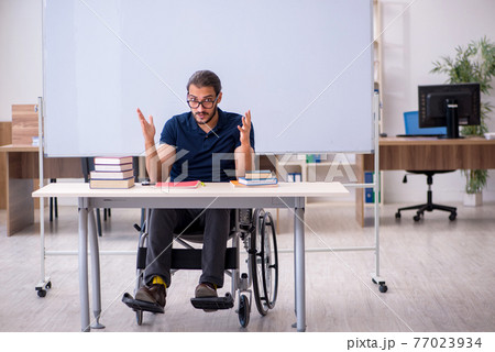 Young male handicapped student in the classroom Young male handicapped student in the classroom 77023934