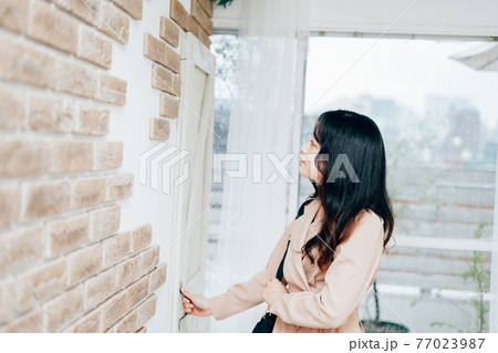 家を出発する若い女性 77023987