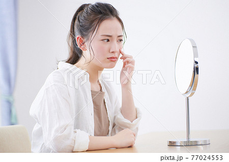 肌トラブルを気にする若い女性 77024553