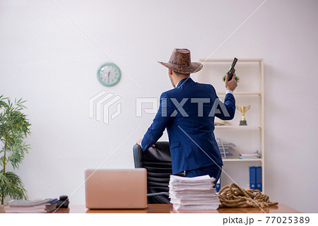 Young cowboy businessman working at workplace Young cowboy businessman working at workplace 77025389