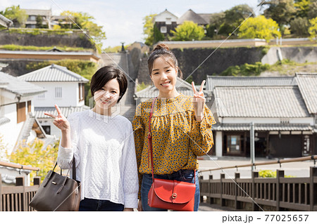女子旅で酢屋の坂を背景に記念撮影をする若い女性と友達 【4月】 77025657