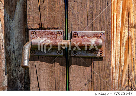 Metal latch on wooden gate closeup 77025947