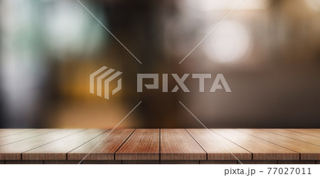 Empty wooden table top with lights bokeh on blur restaurant background. Empty wooden table top with lights bokeh on blur restaurant background. 77027011