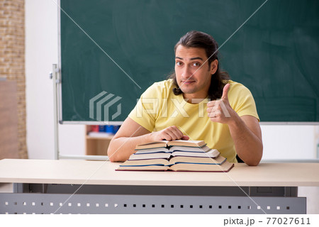 Young male student preparing for exams in the classroom Young male student preparing for exams in the classroom 77027611
