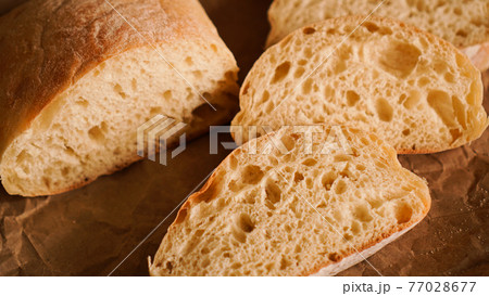 Ciabatta slices on craft paper. Fresh delicious pastries. Fresh homemade bread. Ciabatta slices on craft paper. Fresh delicious pastries. Fresh homemade bread. 77028677