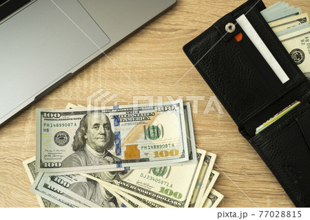 Laptop and wallet with credit card and cash money on a wooden desktop, online payment systems and banking concept. Laptop and wallet with credit card and cash money on a wooden desktop, online payment systems and banking concept. 77028815