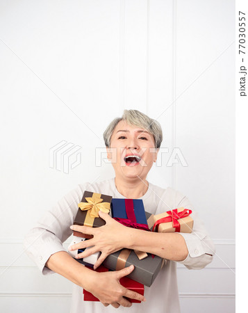 Senior asian woman holding mount of gift boxes, enjoying many best presents. 77030557